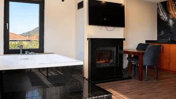 Un baño moderno con una bañera grande, una chimenea y un comedor con una mesa y sillas.