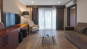 A modern living room with a flat-screen TV, a sofa, a coffee table, and a chair. - Best Western Plus Sapanca (Sapanca)