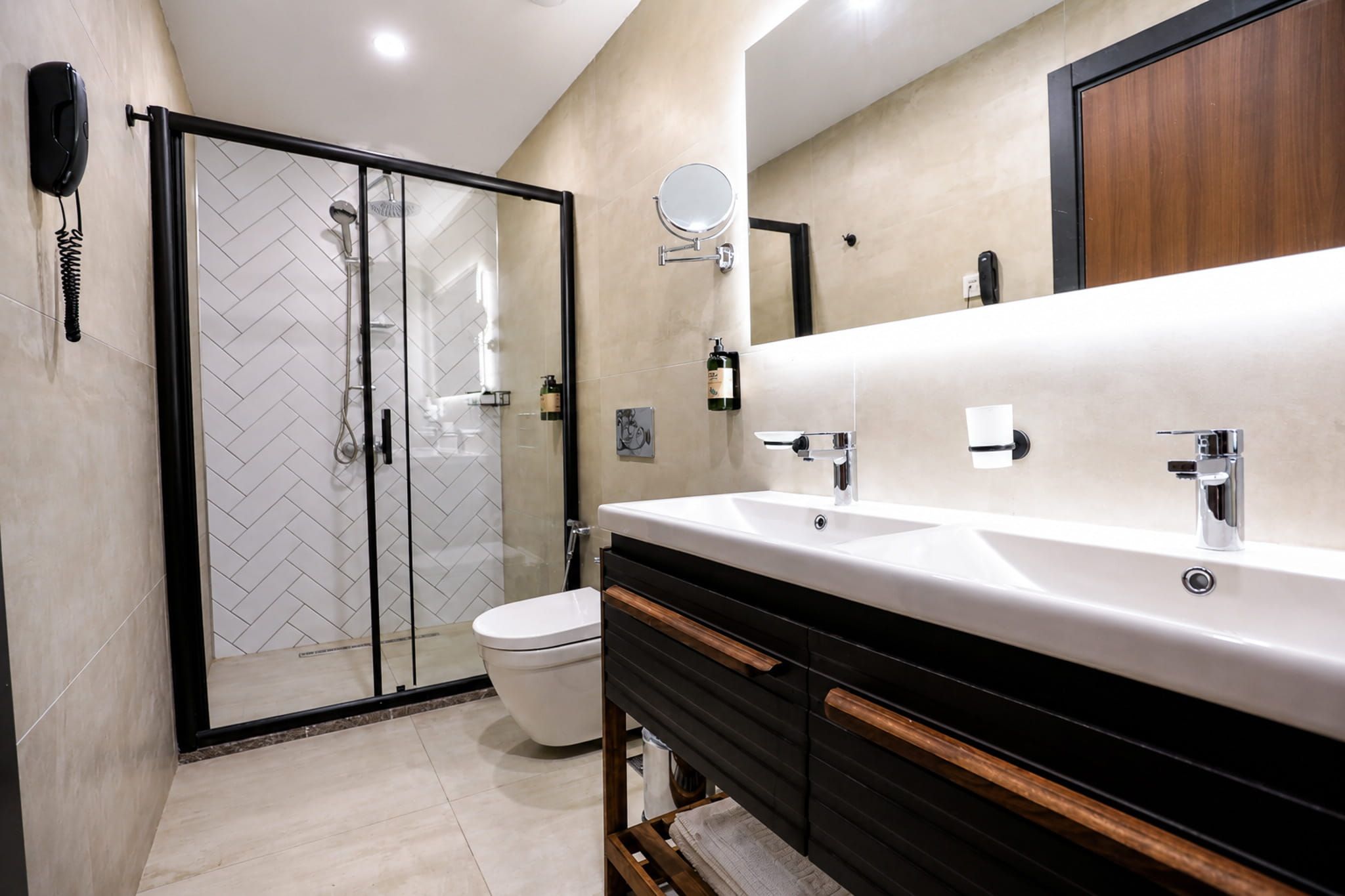 A modern bathroom with a glass shower enclosure, a white toilet, and a vanity with a mirror.