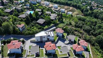 Vista aérea de una zona residencial con casas, una piscina y áreas verdes.