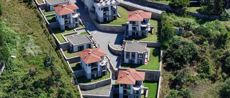 Zona residencial con casas modernas, muros de piedra y un espacio pavimentado en el centro.
