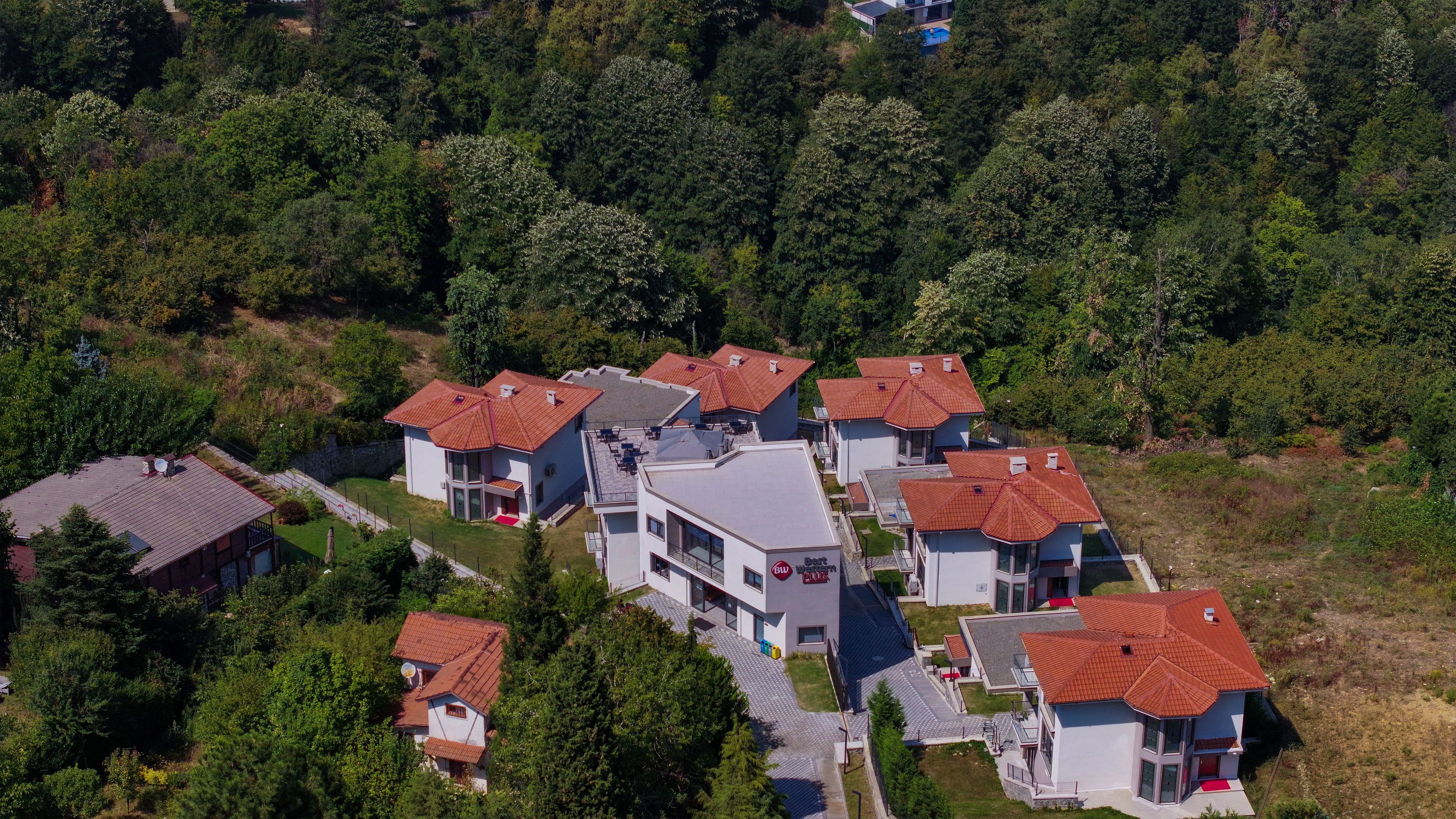 Ein Wohnkomplex mit mehreren Gebäuden, jeweils mit roten Ziegeldächern und moderner Architektur.