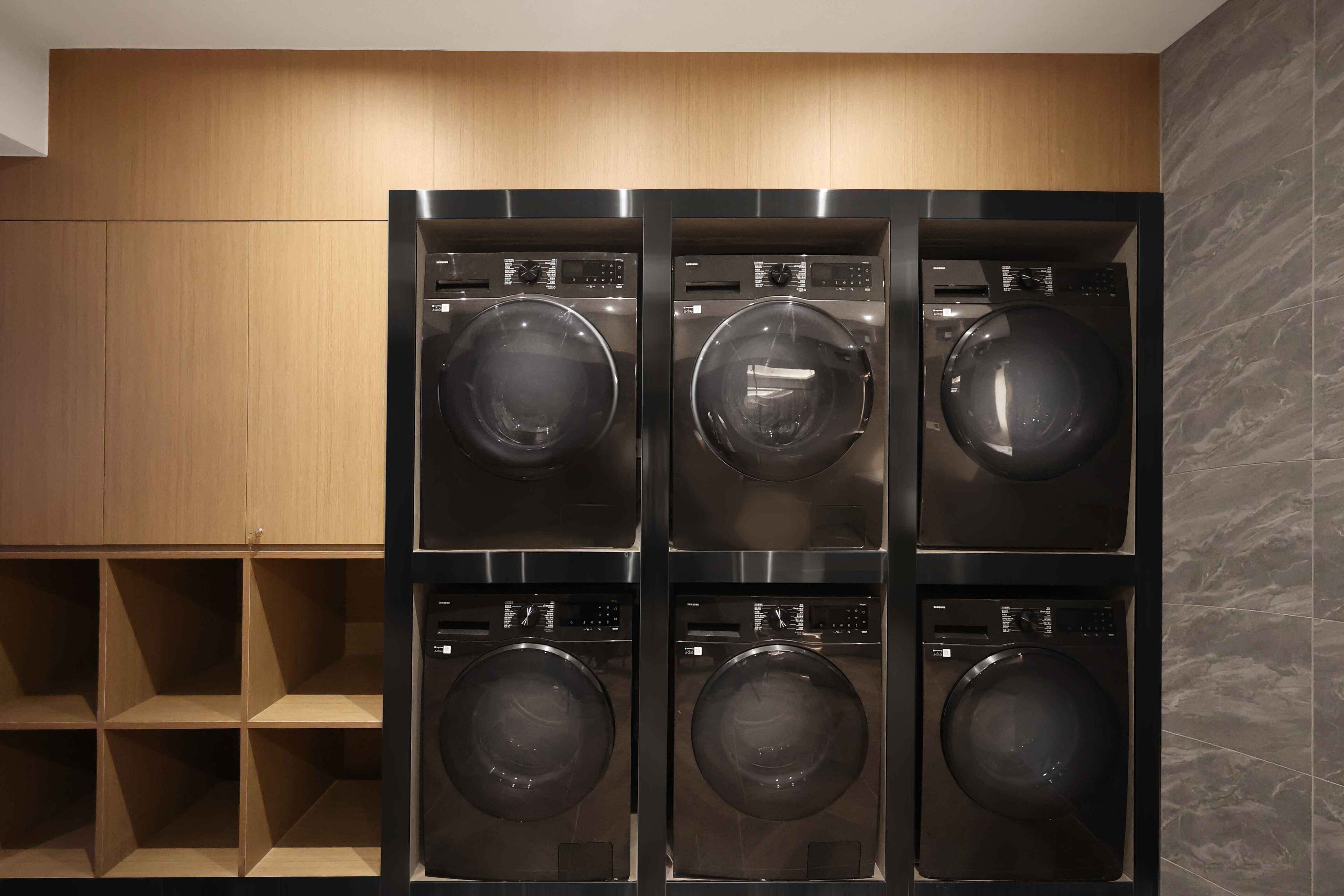 A laundry room with four stacked front-loading washing machines.