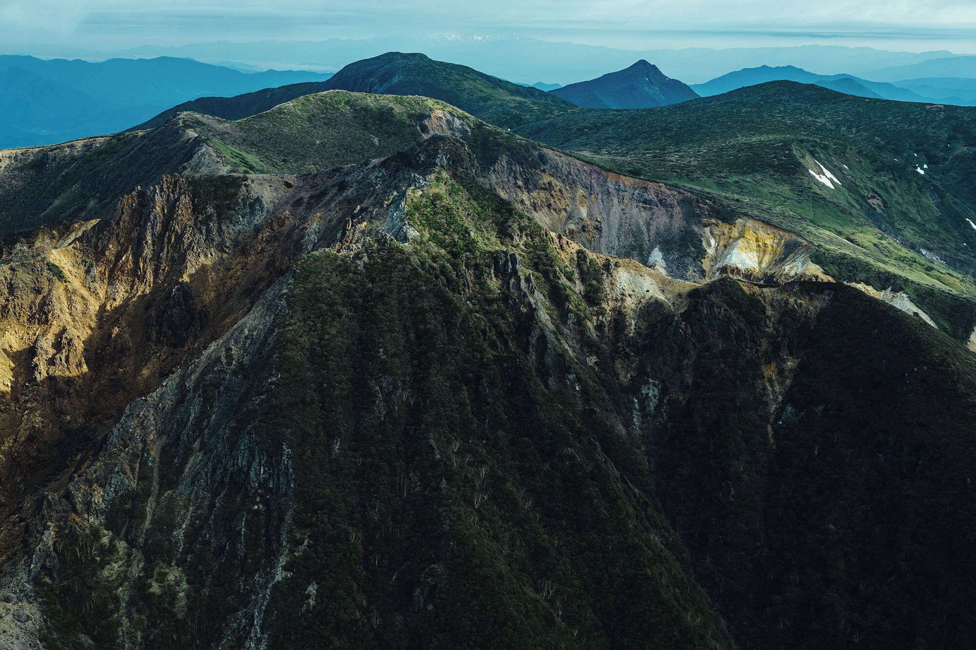 Eine gebirgige Landschaft mit zerklüftetem Gelände und vereinzelter Vegetation.