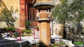 A stone fountain with a circular basin, surrounded by stone walls and a red metal railing. - La Frigoule, a gîte in the heart of the Cévennes Park (Saint-Sébastien-d'Aigrefeuille)