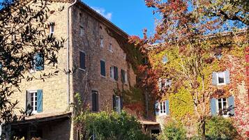 Un bâtiment en pierre doté de nombreuses fenêtres et d’une entrée abritée.