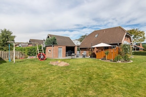 A residential property with a fenced backyard, a wooden deck, and a garage.