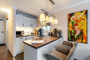 A modern kitchen with a central island, built-in appliances, and pendant lighting.