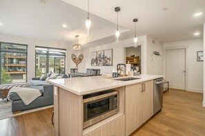 A modern kitchen with a central island, built-in microwave, and a dishwasher.