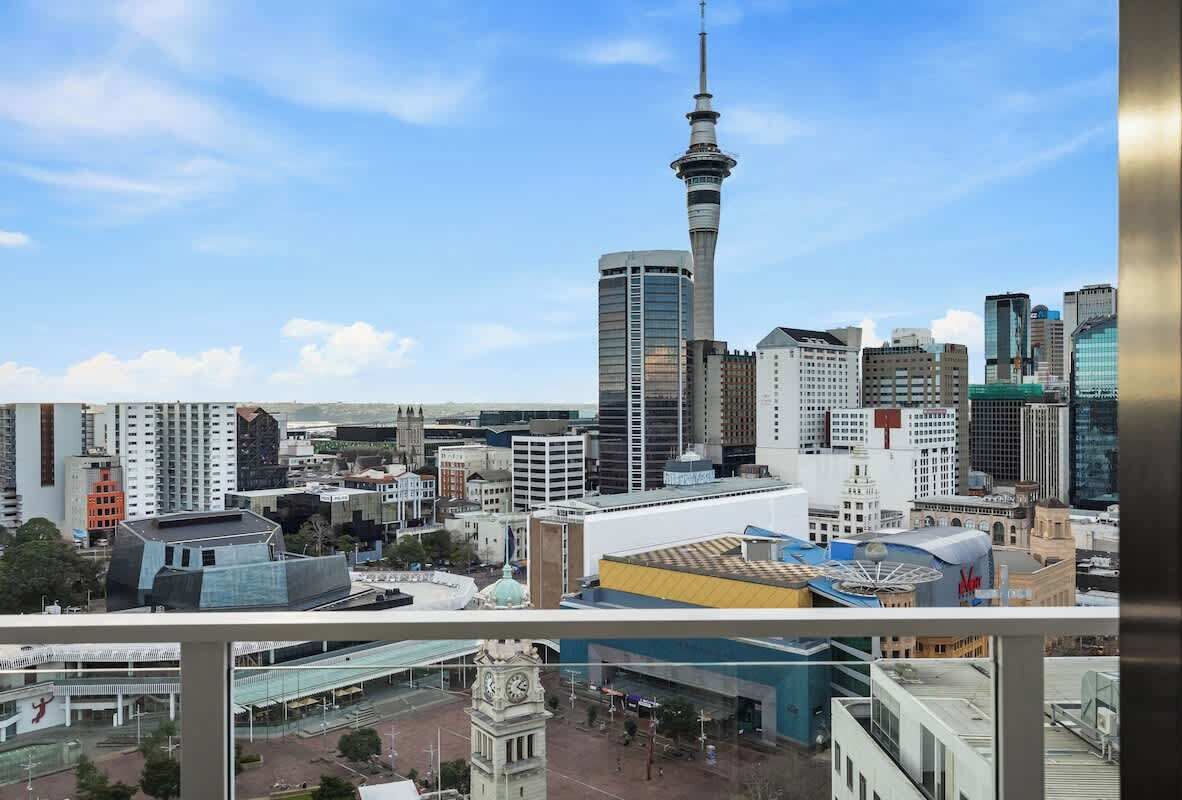 A cityscape with a prominent tower, modern buildings, and a mix of architectural styles.