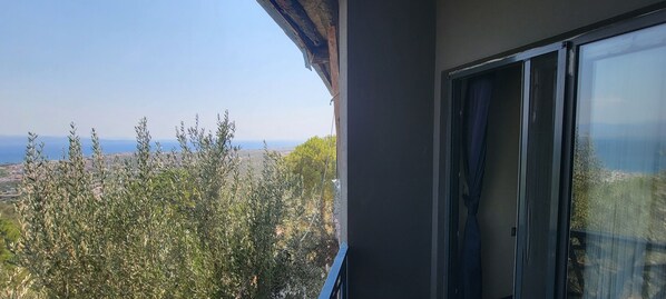 Ein Balkon mit Blick auf Olivenbäume und eine weite Landschaft.