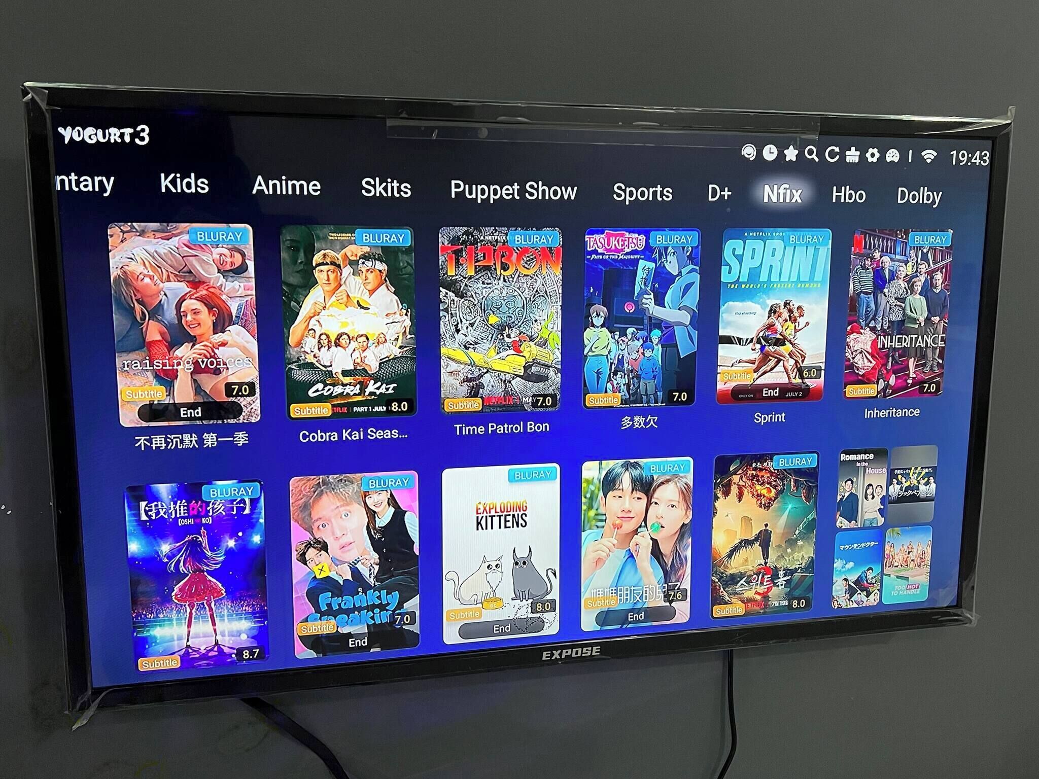 A television screen displaying a selection of anime and movies with subtitles and ratings.