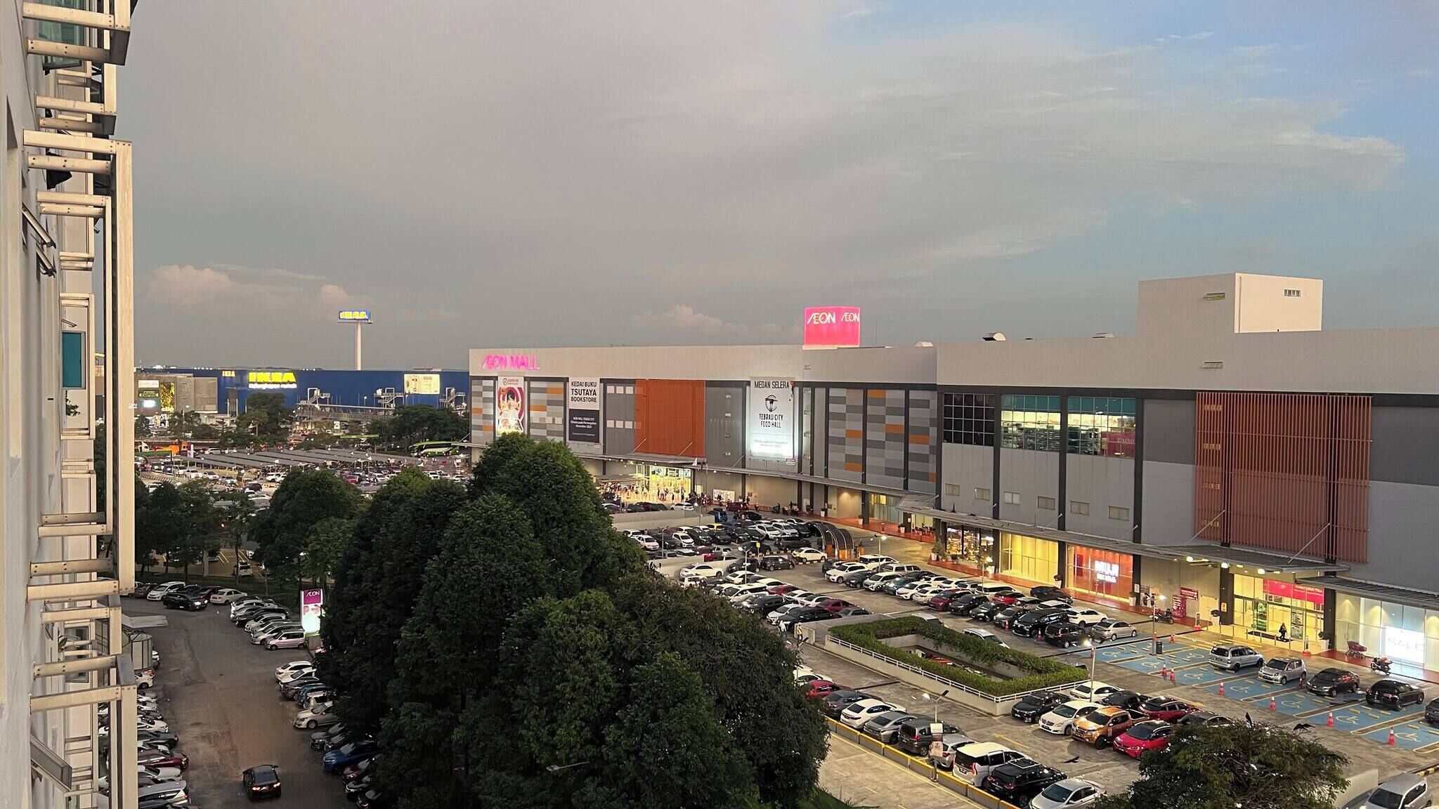 Un centro comercial de varios niveles con diversas tiendas, incluyendo una zona de comida y áreas de estacionamiento.