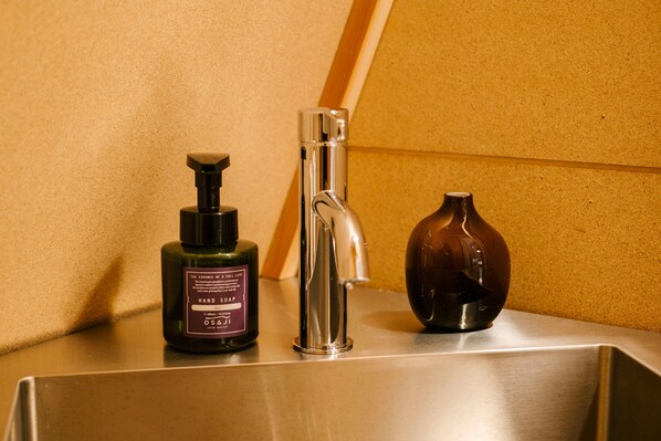 A bathroom sink with a bottle of hand soap and a decorative vase. - SANU 2nd Home Nasu 2nd (Nasu)