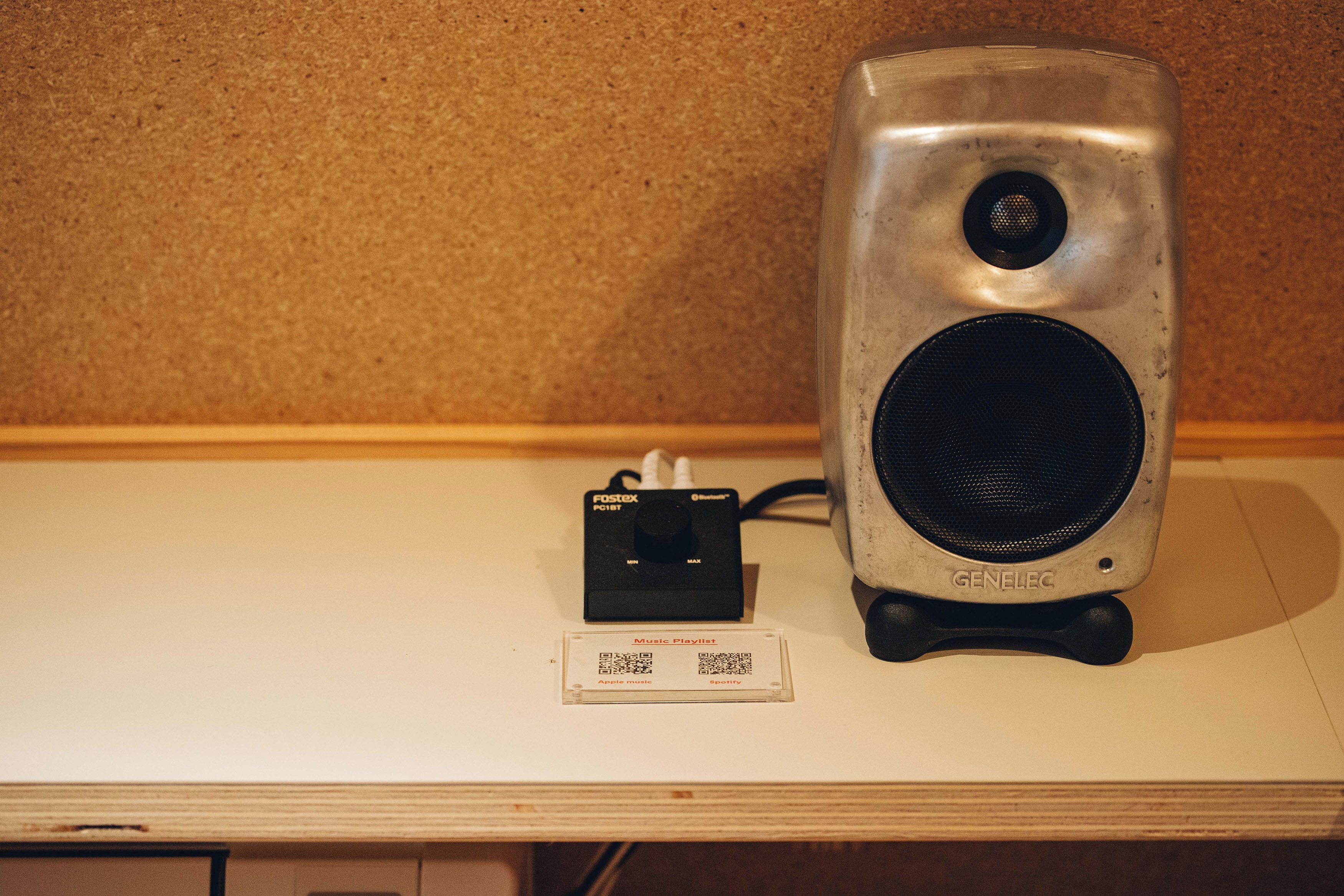 A speaker and a music playlist card on a table.