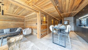 Ein modernes Blockhaus-Interieur mit Essbereich, Sofa und Küche.