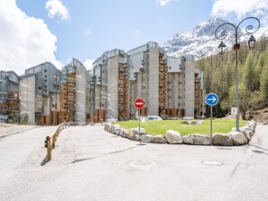 A modern building with a unique architectural design, featuring multiple balconies and a stone facade.