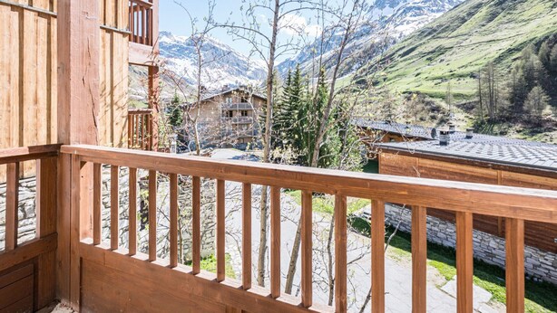 A wooden balcony with a view of mountains and a valley. - Charming Apartment in Chatelard, Val-d'Isère, Direct Access to Slopes, Parking Included (Val-d'Isère)