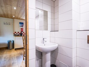 A bathroom with white tiles, a sink, and a mirror. - Cozy renovated apartment for 2-4 guests at ski slopes Val-d'Isère (Val-d'Isère)