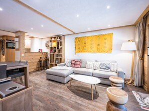Una sala de estar moderna con un sofá seccional, una mesa de centro y un comedor con mesa y sillas.