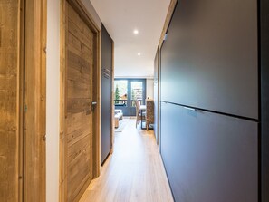 Un couloir avec des portes en bois et un espace cuisine moderne.