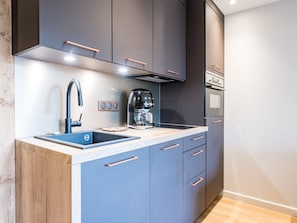 A modern kitchen with a built-in sink, a coffee maker, and a stove.