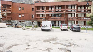 A multi-story building with a wooden facade, a stone base, and a sign indicating 'Bourg St. Maurice Centre Ville.'