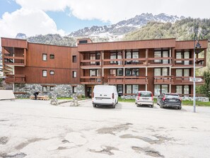 Un edificio de varios pisos con fachada de madera, base de piedra y un letrero que indica 'Bourg St. Maurice Centre Ville'.