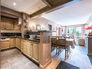A spacious kitchen with wooden cabinets, a large island, and a dining area with a table and chairs.