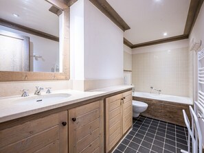 Un bagno con mobili in legno, un lavandino, un WC e una vasca da bagno.