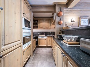 Una cocina con armarios de madera, estufa, lavamanos y encimera.