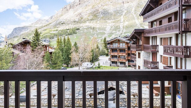 A mountain lodge with wooden balconies and stone walls, set against a backdrop of snow-capped peaks. - Renovated Studio Cabin - Ski-in/Ski-out - WIFI (Val-d'Isère)