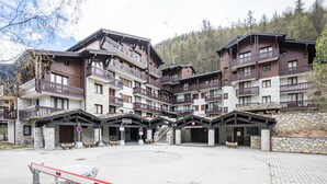A multi-story hotel with balconies, stone facade, and a central courtyard. - Renovated Studio Cabin - Ski-in/Ski-out - WIFI (Val-d'Isère)