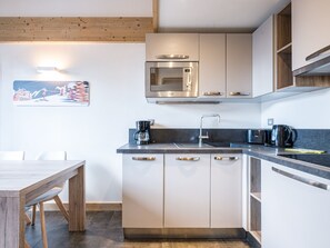 A modern kitchen with a built-in microwave, a coffee maker, and a sink.