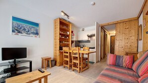 Un salón acogedor con una mesa de comedor de madera, un sofá y una televisión.
