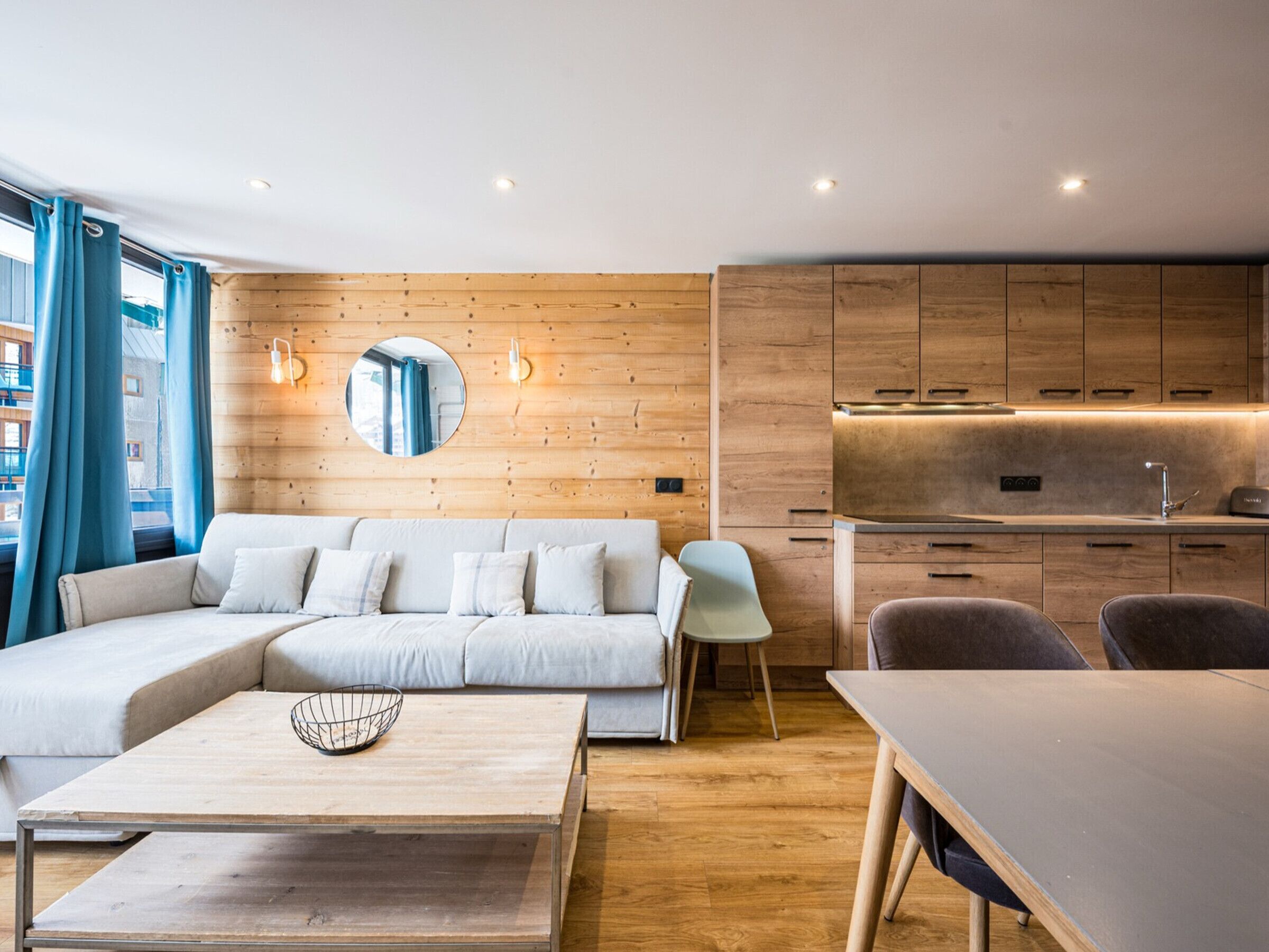 A modern living room with a sofa, a coffee table, and a dining table.