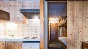 A compact kitchen with a Frigelux refrigerator, a stove, and wooden cabinets. - Comfortable studio in center, balcony, 2-3 pers. (Val-d'Isère)