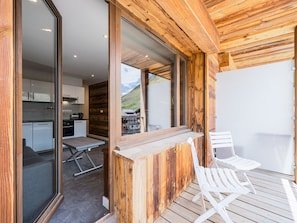 A modern kitchen with white cabinets and a dining area with a wooden table and white chairs.