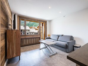 A modern living room with a sofa, coffee table, and wooden accents.