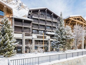 Un hôtel à plusieurs étages, doté de balcons, de piliers en pierre et d’une enseigne indiquant « LE DÔME ».