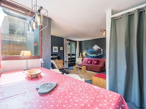 A room with a bed, a sofa, a table, and a wall with a painting.