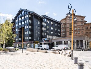 Um edifício moderno com fachada preta, uma placa com a inscrição 'SKIMTUMI' e um estabelecimento chamado 'POINT BREAK'.