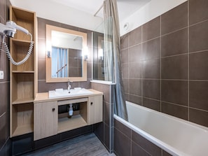 A modern bathroom with a shower, a sink, a mirror, and a towel rack.