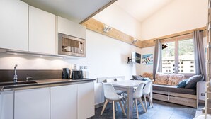 A modern kitchen with white cabinets, a built-in microwave, and a coffee machine. - Renovated Studio with Mezzanine – Val-d'Isère Center (Val-d'Isère)