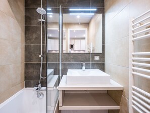 A modern bathroom with a glass-enclosed shower, a white sink, and a mirror. - Renovated Studio with Mezzanine – Val-d'Isère Center (Val-d'Isère)