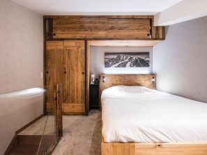 A bedroom with a bunk bed, wooden wardrobe, and a framed picture on the wall. - Renovated studio with balcony in Val-d'Isère center (Val-d'Isère)