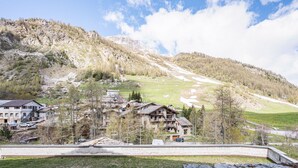 A mountainous village with traditional stone buildings, a clear sky, and a view of the surrounding landscape.