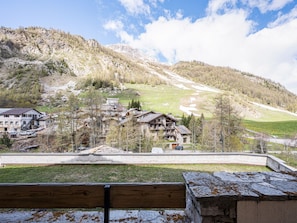 Un village de montagne aux maisons traditionnelles en pierre, avec un ciel dégagé et une vue imprenable sur les environs.