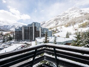 A multi-story hotel with a modern architectural design, located in a snowy mountainous area with views of surrounding peaks and a ski resort. - Comfortable ski-in/ski-out studio in Val-d'Isère (Val-d'Isère)