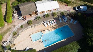 An aerial view of a property with a swimming pool, lounge chairs, and a covered area with umbrellas. - 52m² Chalet with Terrace in Sauveterre-de-Rouergue (Sauveterre-de-Rouergue)